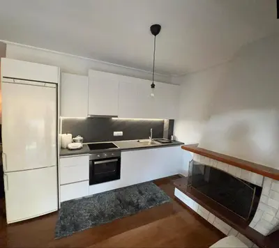 a kitchen with white cabinets and a sink and a refrigerator at glyfada luxury home in Athens
