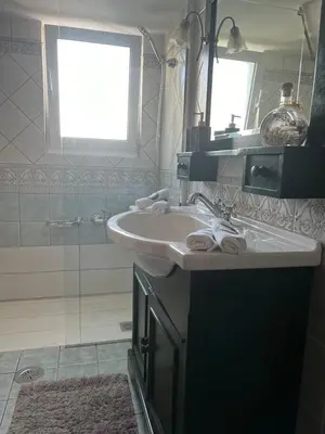 a white bathroom with a sink and a shower at glyfada luxury home in Athens