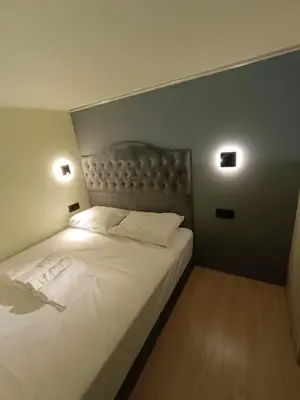a bedroom with a white bed with two lights on it at The loft in Piraeus
