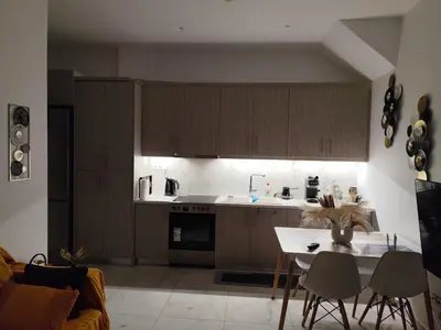 a kitchen with wooden cabinets and a table and chairs at The loft in Piraeus
