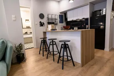 a kitchen with three bar stools in front of a counter at Cosy Contemporary Luxury Urban Retreat in Athens in Athens