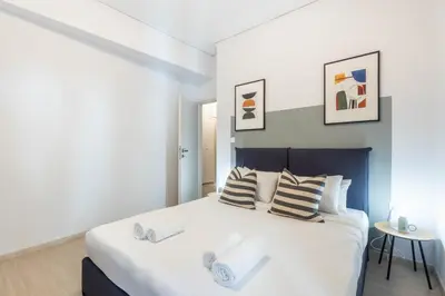 a bedroom with a large white bed with two pillows at Sunlit Serenity Cozy 1bdrm Escape in Athens in Athens