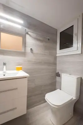 a bathroom with a white toilet and a sink at Sunlit Serenity Cozy 1bdrm Escape in Athens in Athens