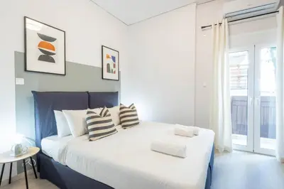 a bedroom with a large white bed with pillows at Sunlit Serenity Cozy 1bdrm Escape in Athens in Athens