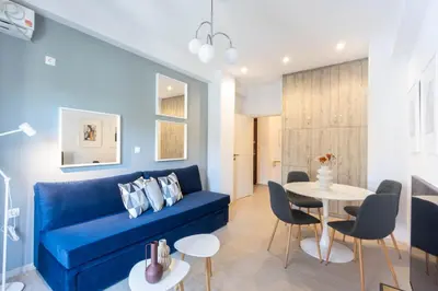 a living room with a blue couch and a table at Sunlit Serenity Cozy 1bdrm Escape in Athens in Athens