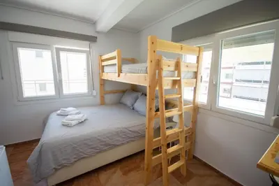 a bunk bed in a room with two windows at Birdhouse Apartment Athens in Athens