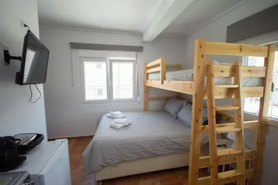 a bedroom with two bunk beds and a television at Birdhouse Apartment Athens in Athens