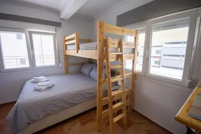 a bunk bed in a room with two windows at Birdhouse Apartment Athens in Athens