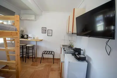 a small kitchen with a television on the wall at Birdhouse Apartment Athens in Athens