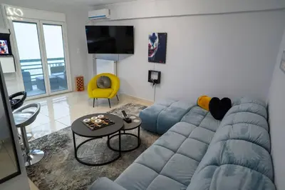 a living room with a blue couch and a table at Fresh Spicy 1bd Amusement Arcade in Athens
