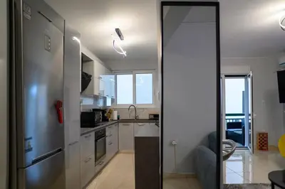a kitchen with a stainless steel refrigerator and white cabinets at Fresh Spicy 1bd Amusement Arcade in Athens