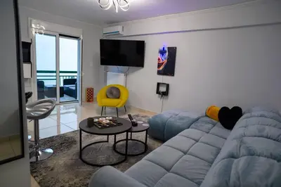 a living room with a blue couch and a yellow chair at Fresh Spicy 1bd Amusement Arcade in Athens