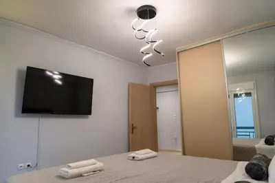 a bedroom with a bed with a television on the wall at Fresh Spicy 1bd Amusement Arcade in Athens