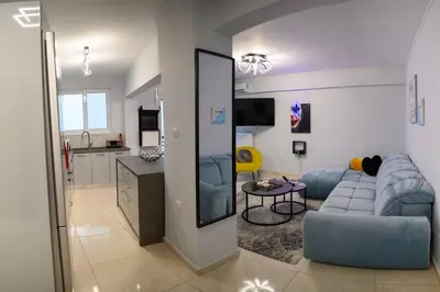 a living room with a blue couch and a kitchen at Fresh Spicy 1bd Amusement Arcade in Athens