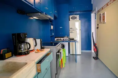 a kitchen with blue walls and a white refrigerator at BlueXenia 1 bedroom Retro Luxury in Athens