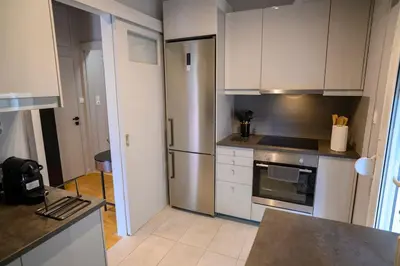 a kitchen with white cabinets and a stainless steel refrigerator at Seaview Orchid 2 bed Elegance in Athens