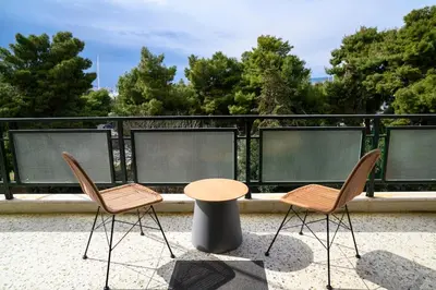two chairs and a table on top of a balcony at Seaview Orchid 2 bed Elegance in Athens