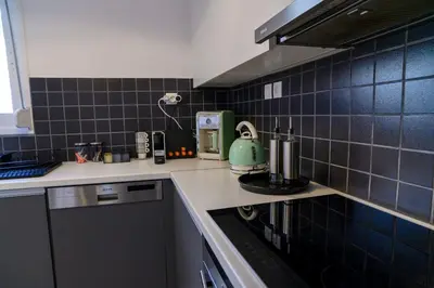 a kitchen with a green tea kettle on the stove at Debonair 1 bedroom premium haven in Athens in Athens