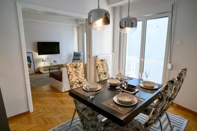 a dining room table and chairs in a living room at Debonair 1 bedroom premium haven in Athens in Athens