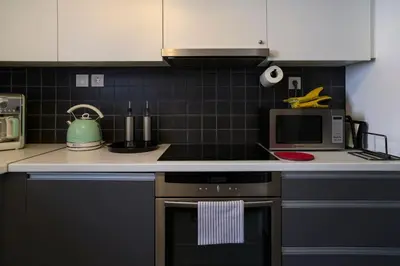 a kitchen with a stove and a microwave at Debonair 1 bedroom premium haven in Athens in Athens