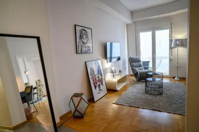 a living room with a chair and a mirror at Debonair 1 bedroom premium haven in Athens in Athens