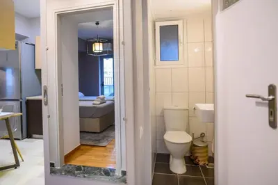 a bathroom with a toilet and a bedroom at Subtle 3 bed Luxury with a View in Athens