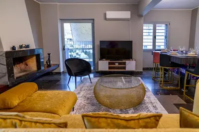 a living room with a couch and a table and a television at Subtle 3 bed Luxury with a View in Athens