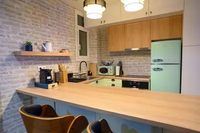 a kitchen with a green refrigerator and wooden cabinets at Hidden Garden of Kallithea in Athens