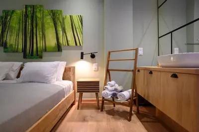 a bathroom with a bed and a sink and a chair at Hidden Garden of Kallithea in Athens