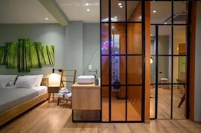 a living room with a bed and a glass wall at Hidden Garden of Kallithea in Athens