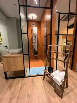 a bathroom with aanding tub and a glass wall at Hidden Garden of Kallithea in Athens