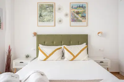 a bedroom with a white bed with three pictures on the wall at The Business Suite by CloudKeys in Athens