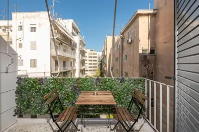 a wooden table and chairs on a balcony at The Business Suite by CloudKeys in Athens