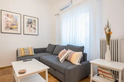 a living room with a couch and a table at The Business Suite by CloudKeys in Athens