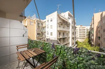 a bench sitting on a balcony with buildings at The Business Suite by CloudKeys in Athens
