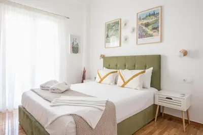 a bedroom with a large bed with white sheets at The Business Suite by CloudKeys in Athens