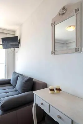a living room with a couch and a mirror at Breathtaking seaview studio in Athenian Riviera in Athens