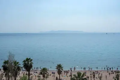 a group of people on a beach near the water at Breathtaking seaview studio in Athenian Riviera in Athens