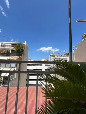 a balcony with a fence and a palm tree at Qqueen House in Piraeus