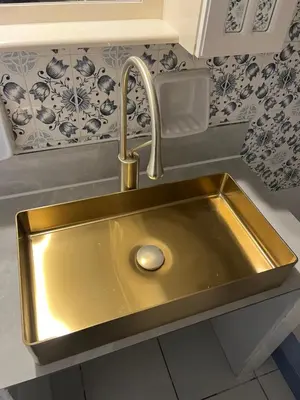 a gold sink in a kitchen with blue and white wallpaper at Qqueen House in Piraeus