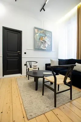 a living room with a black door and a table at Stoa House Airport in Koropíon
