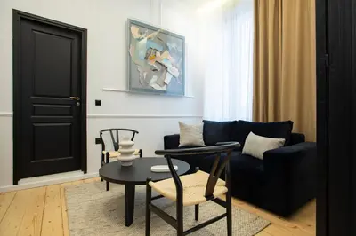 a living room with a blue couch and a table at Stoa House Airport in Koropíon