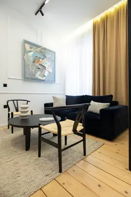 a living room with a blue couch and a table at Stoa House Airport in Koropíon