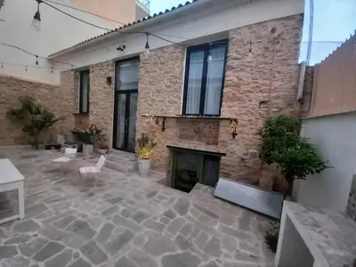 a brick building with a fireplace in a courtyard at Stoa House Airport in Koropíon