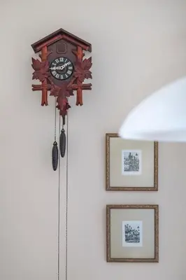 a clock hanging on a wall with two pictures at Family Apt in Glyfada-Kyprou, by Comfortbnb in Athens