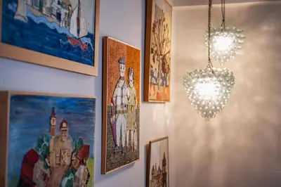 a chandelier hanging from a wall with paintings and pictures at Family Apt in Glyfada-Kyprou, by Comfortbnb in Athens