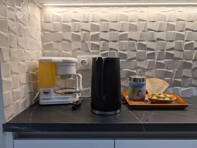 a kitchen counter with a coffee maker and a plate of food at Luxury & Spacious Apartment in Athens in Athens