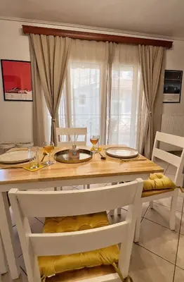 a dining room table with two chairs and a table with glasses at H&H cozy retreat ,Fireplace and Parking in Piraeus
