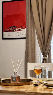 a table with a glass of wine and a picture of a car at H&H cozy retreat ,Fireplace and Parking in Piraeus