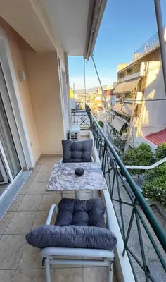 a balcony with a couch and a table on a building at H&H cozy retreat ,Fireplace and Parking in Piraeus